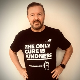 Person in a black "The Only Cure Is Kindness" t-shirt posing with hands on hips against a light background.