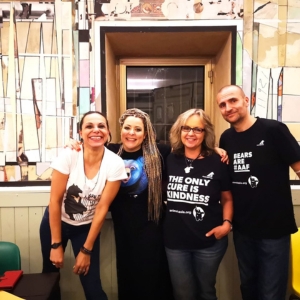 Group indoors posing together, wearing shirts with kindness and bear protection messages.