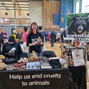 Animal charity stall with merchandise, educational materials, and a banner reading "Help us end cruelty to animals."