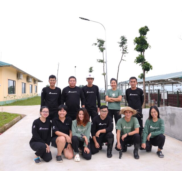 Animals Asia team members posing outdoors in uniforms near sanctuary buildings and enclosures.