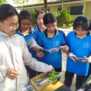 A group of young school children reading leaflets about bear conservation.