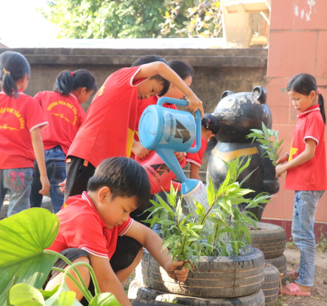 School children tending plants in herbal garden