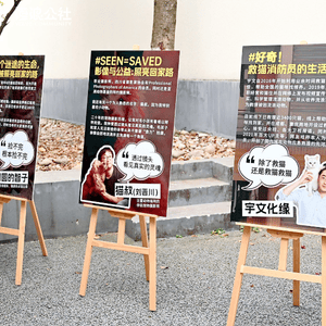 Three easels supporting large posters printed in Chinese depicting humans with companion animals