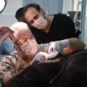 Three vets look at the mouth of a moon bear asleep on surgical table