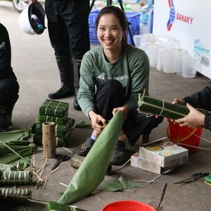 A woman in animals asia tshirt laughs with colleagues as they make natural structures
