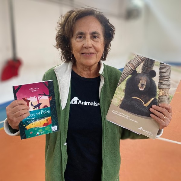 Giuliana Corea tiene in mano un suo libro e un opuscolo di Animals Asia.