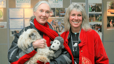 Two women stand next to each other smilling.