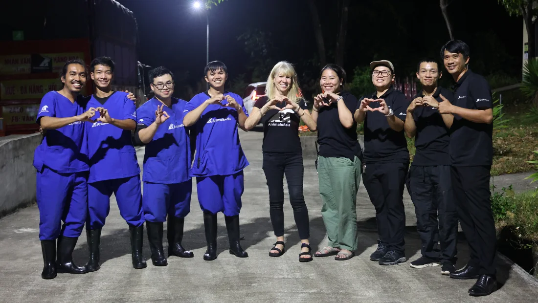 Animals Asia rescue team members pose together at night after a successful bear rescue mission